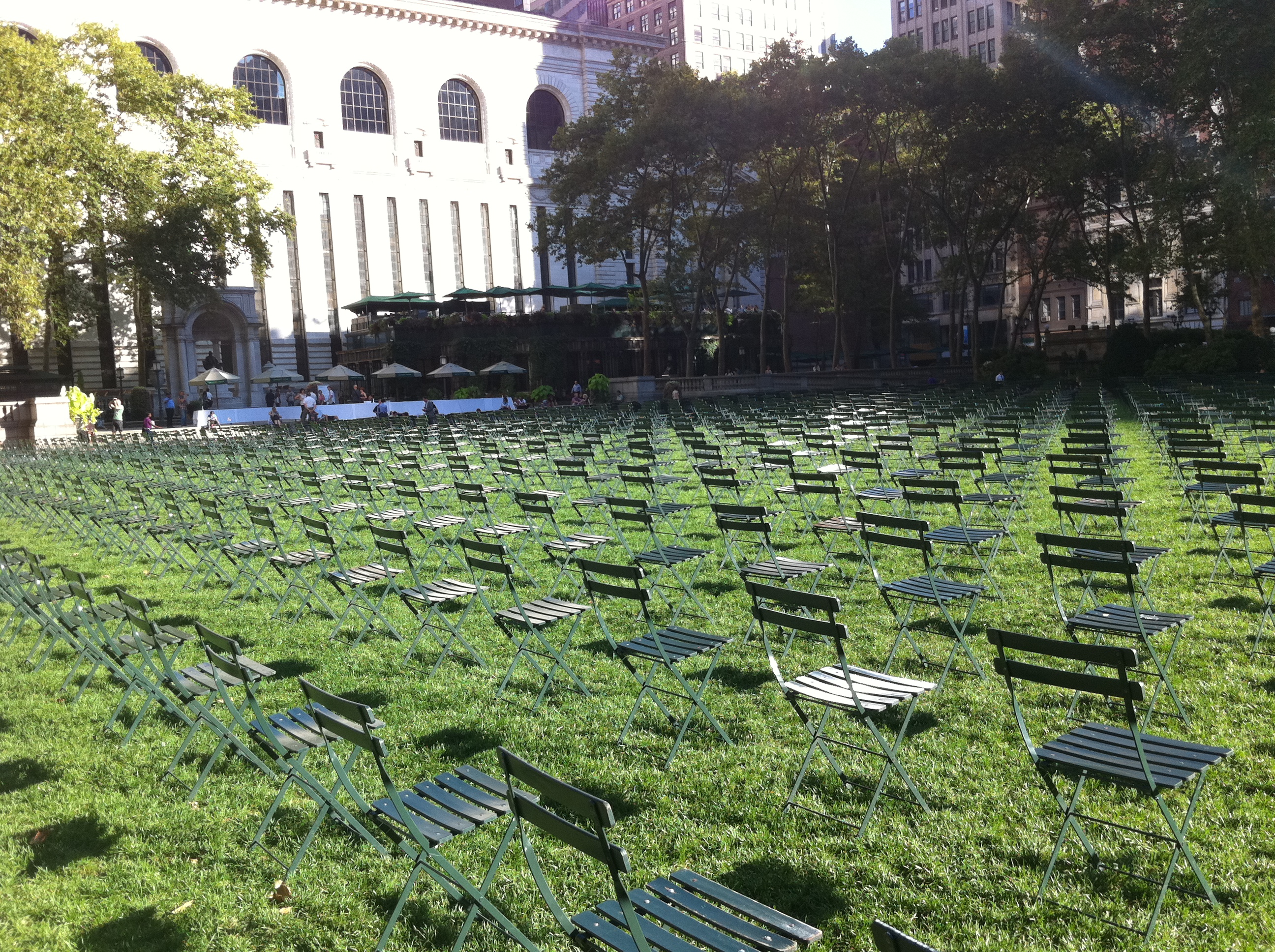 Thousands of empty green chairs arranged across the Bryant Park lawn during the tenth anniversary remembrance of September 11, with the New York Public Library in the background.